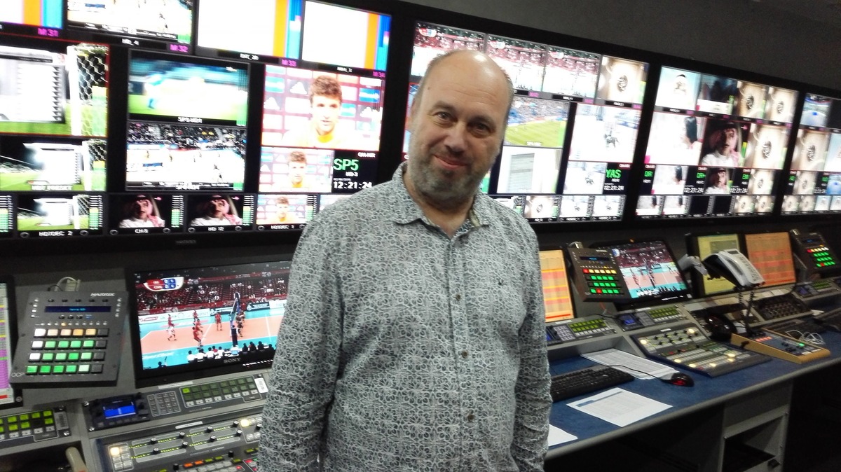 Melchior Busschers in a broadcast control room with a wall of multiview monitors.