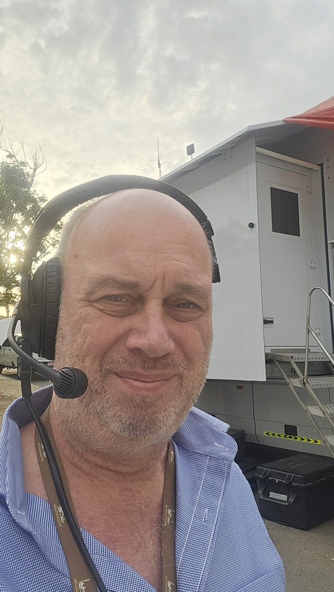 Melchior Busschers wearing a broadcast headset outdoors.