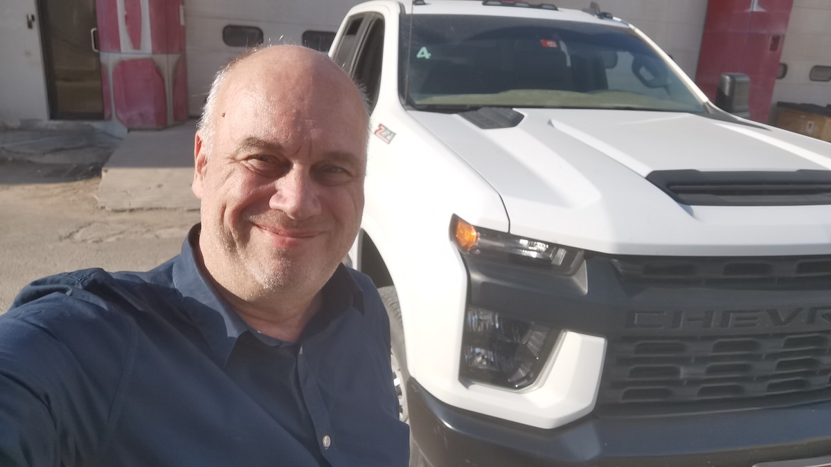 Melchior Busschers standing beside a white vehicle.